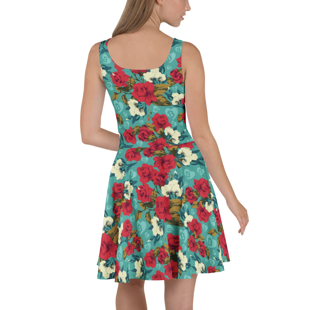 Woman wearing a floral dress with red and white flowers and bitcoin hearts on a teal background