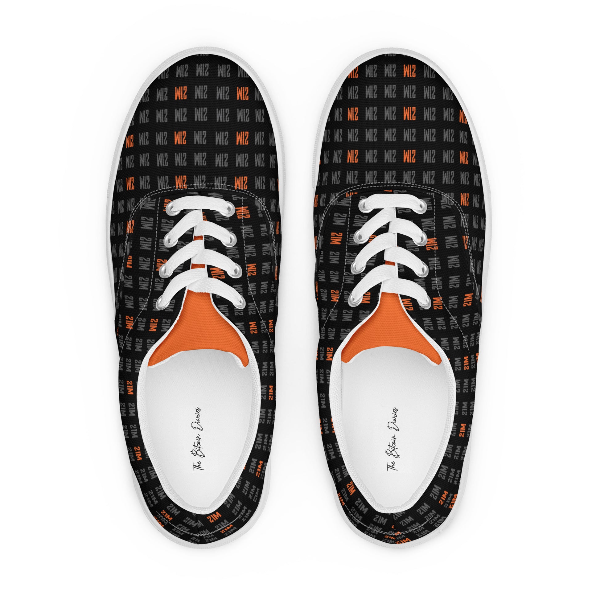 Pair of black sneakers with orange 21 million accents and white laces on a white background