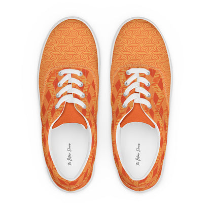 Pair of orange sneakers with white laces on a white background