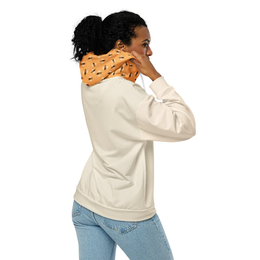 Woman wearing a beige hoodie and light blue jeans with a patterned orange hoood with bitcoin bees on a white background