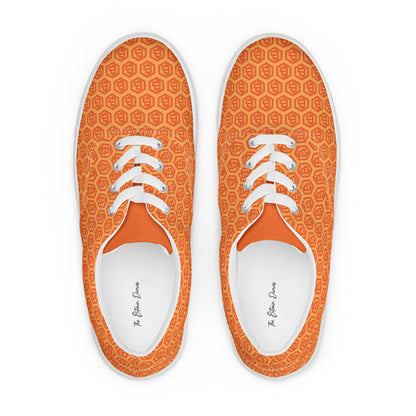 Pair of orange sneakers with bitcoin symbols white laces on a white background