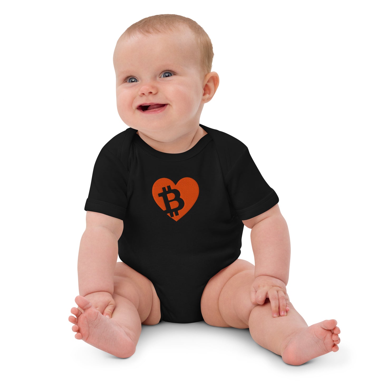 Baby wearing a black onesie with a heart-shaped Bitcoin logo on a white background