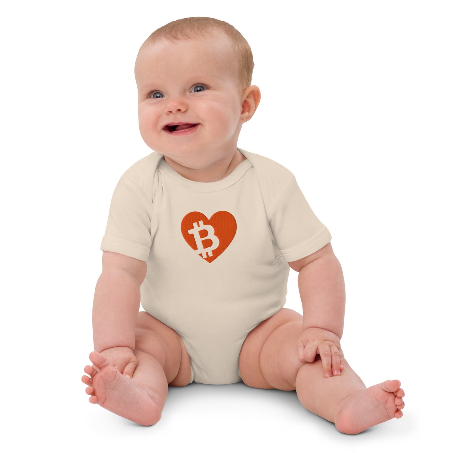 Baby wearing a onesie with a heart-shaped Bitcoin logo on a white background