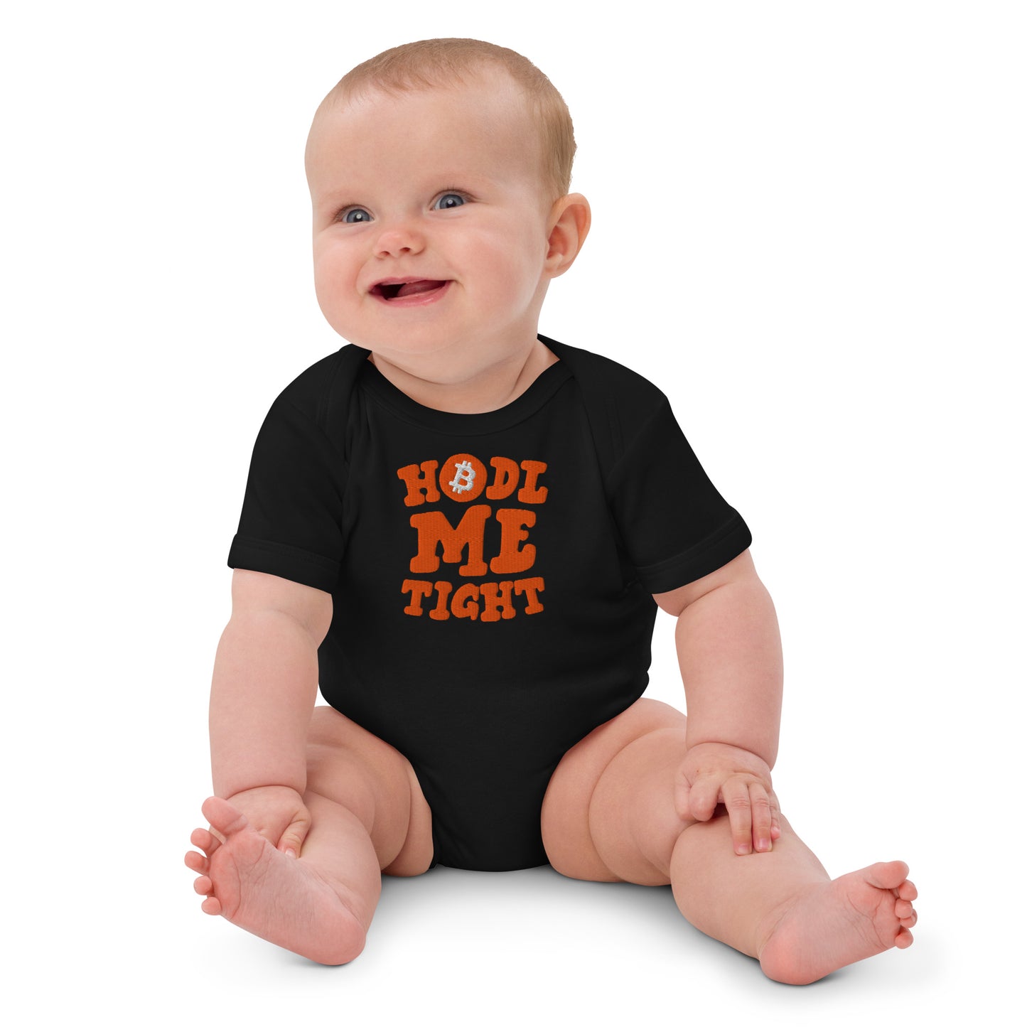 Baby wearing a black onesie with orange hodl me tight text on a white background