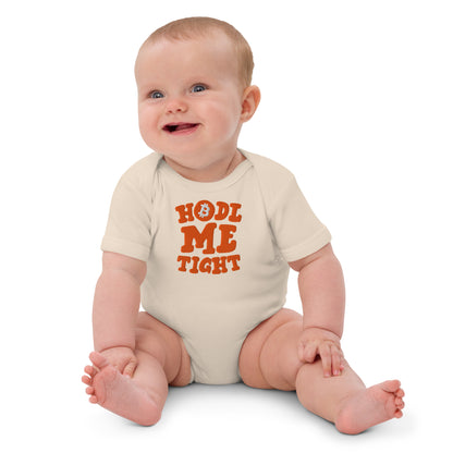 Baby wearing a onesie with 'HOLD ME TIGHT' text on a white background