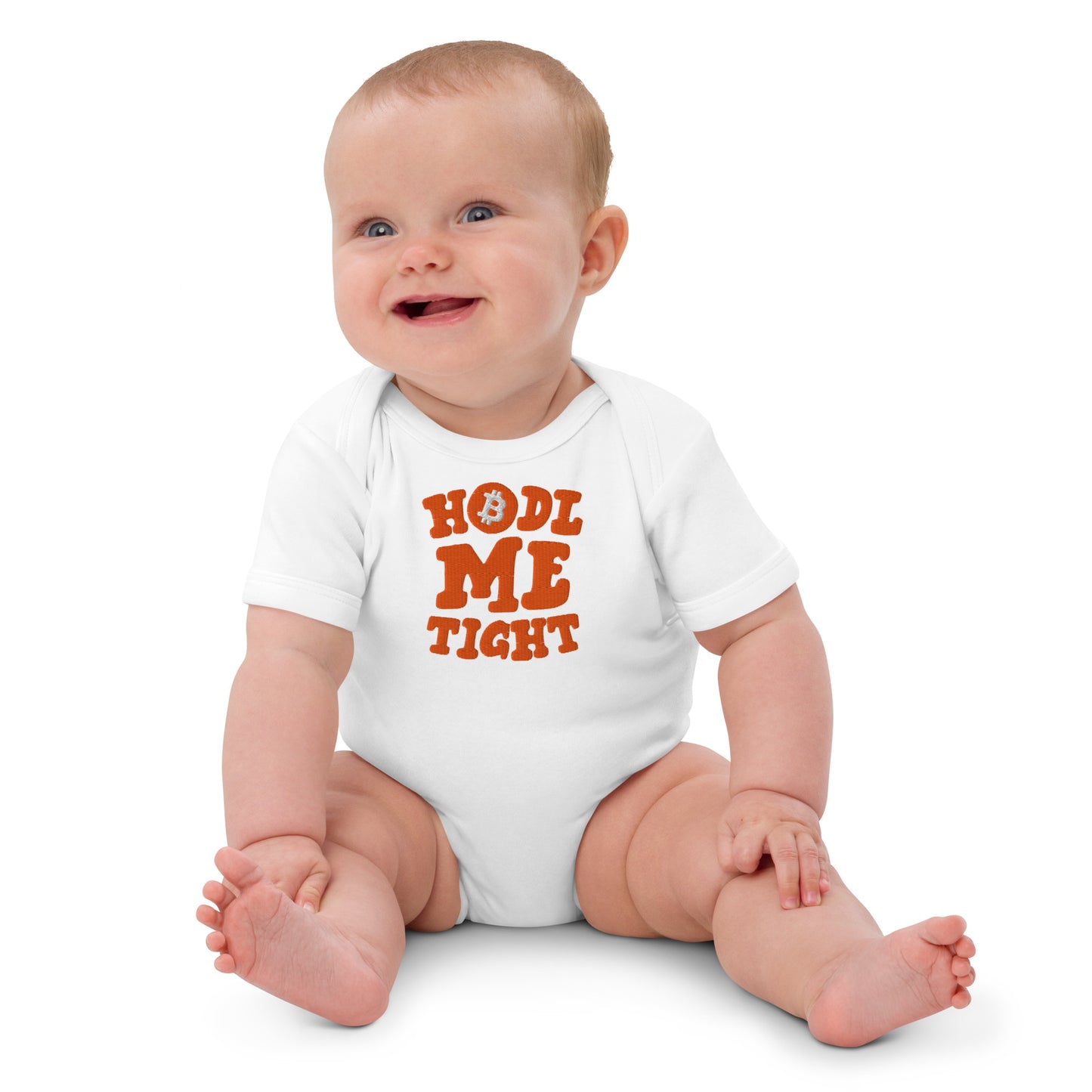 Baby wearing a white onesie with 'HOLD ME TIGHT' text on a white background