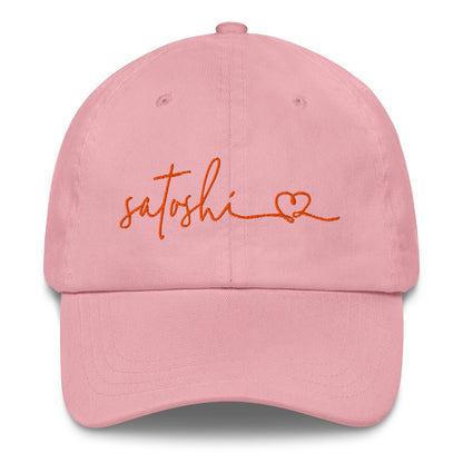 Pink cap with 'satoshi' and a heart embroidered in orange on a white background