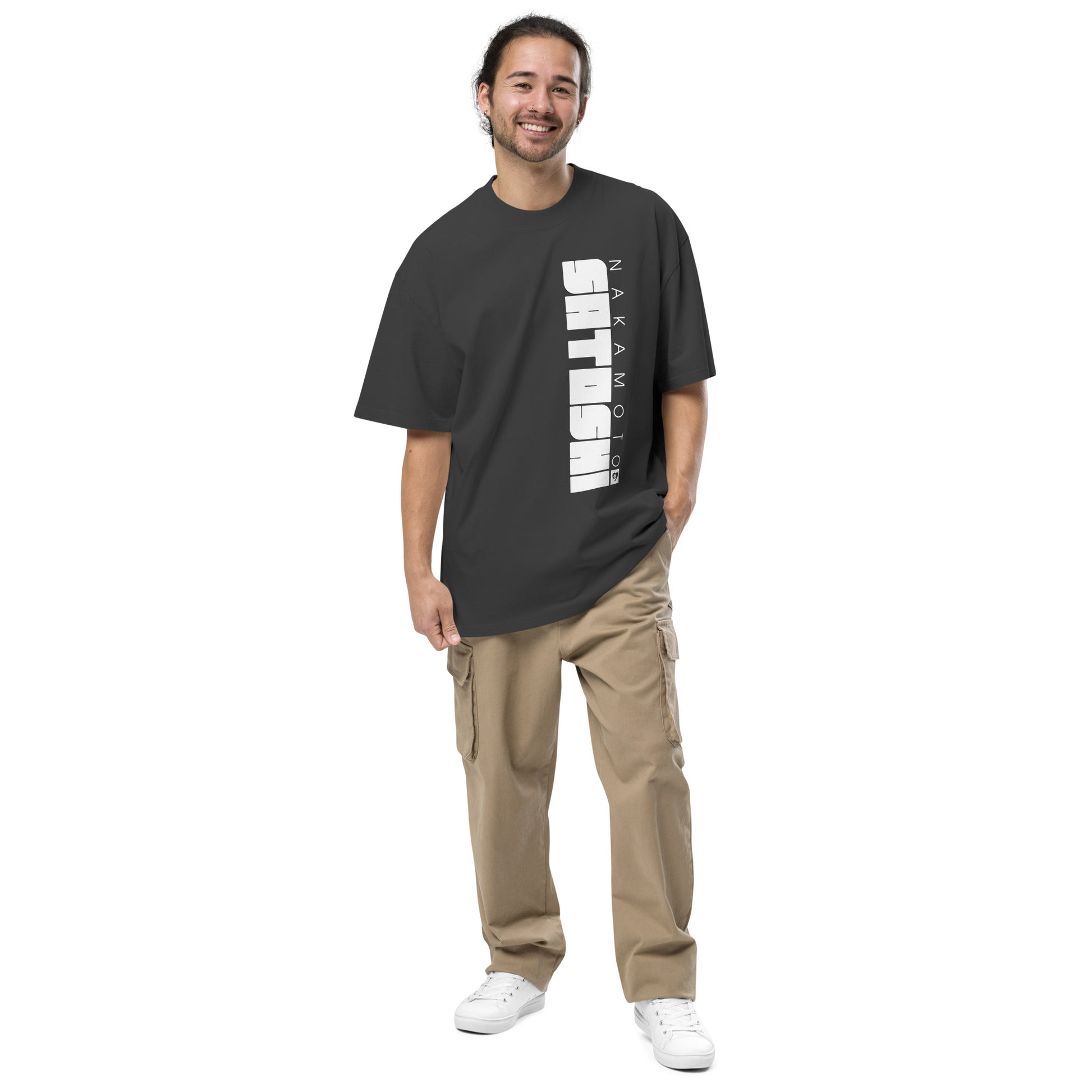 Man wearing a black t-shirt with white satoshi nakaamoto text and beige pants on a white background